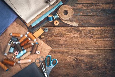 Threads and fabrics of different colors, scissors and a thimble with a ribbon Stock Photos