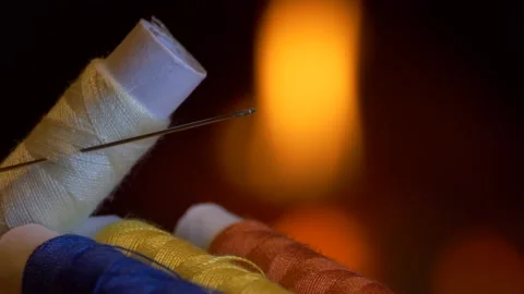 Threads. Colored spools of thread lie on the table against the firelight. Video stock 143637939