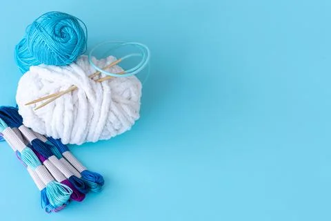 Threads of different colors on a blue background. Stock Photos