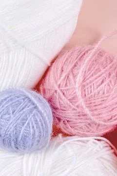 Threads for knitting in white, gray and pink colors on a pink background Stock Photos