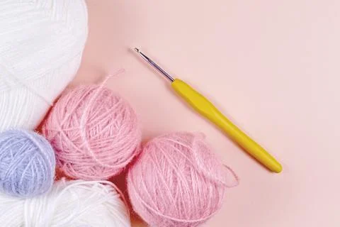 Threads for knitting in white, gray and pink colors on a pink background Stock Photos