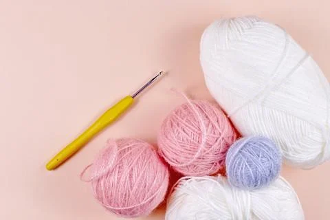 Threads for knitting in white, gray and pink colors on a pink background Stock Photos