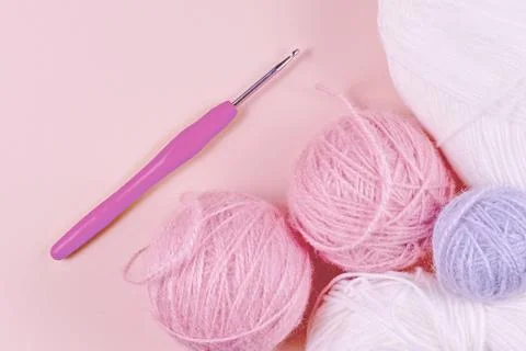Threads for knitting in white, gray and pink colors on a pink background Stock Photos