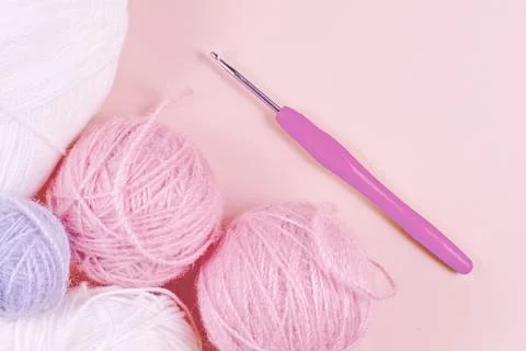 Threads for knitting in white, gray and pink colors on a pink background Stock Photos
