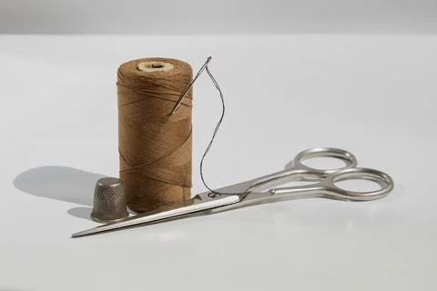 Threads, needle, scissors and thimble on white background, sewing kit, vintag Stock Photos