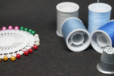 Threads , needles, thimbles means for sewing a hobby of needlework on a black ba Stock Photos