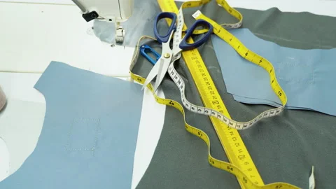 Threads, pattern, scissors, tape measure, and a sewing machine. Workplace of Stock Footage 230939342