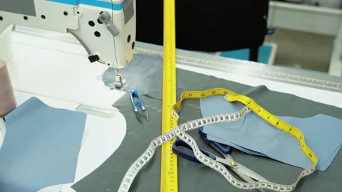Threads, pattern, scissors, tape measure, and a sewing machine. Workplace of Stock Footage 230939348