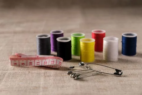 The threads with sewing accessories lie on a thick fabric. Stock Photos