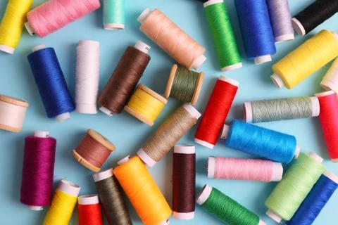 Threads for sewing in different colors on a colored background Stock Photos
