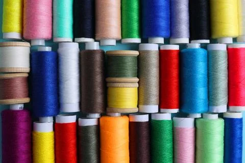 Threads for sewing in different colors on a colored background Stock Photos