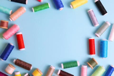 Threads for sewing in different colors on a colored background Stock Photos
