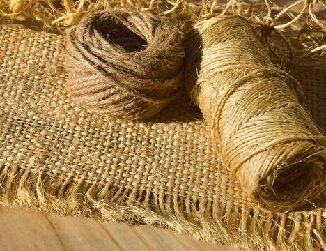 Threads for weaving macrame on the background of burlap. Stock Photos