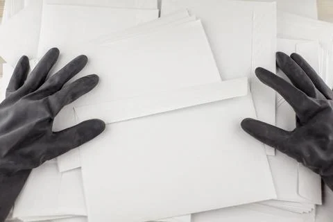 The threat in an envelope: People in protective impermeable gloves collects a Stock Photos