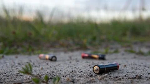 Three AAA batteries on the the ground. The concept of environmental protection Foto stock