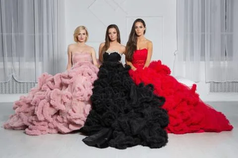 Three adorable girlfriends posing in the studio Stock Photos