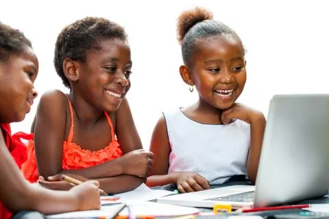 Three african kids laughing at scene on laptop. Stock Photos