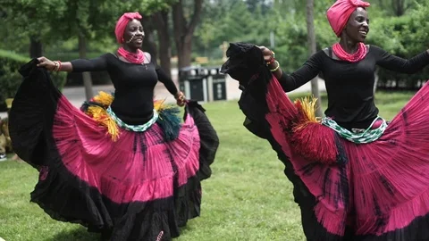 Three african women dancing folk dance in traditio.costumes with coats of skirts Stock Footage