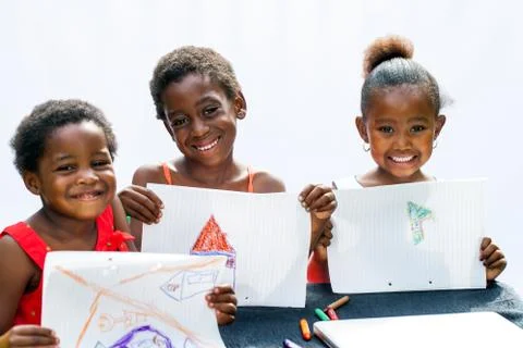Three african youngsters showing their drawings. Foto stock