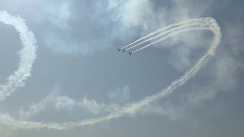 Three aircraft perform complex flight path Leave beautiful pattern in sky Stock Footage 120388960