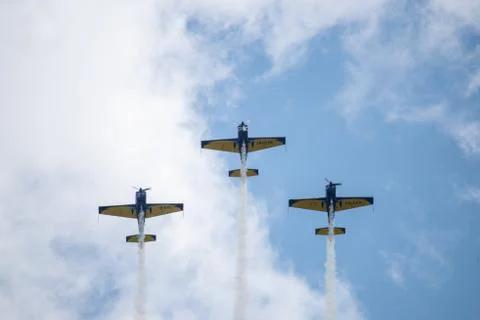 Three airplanes in the sky within clouds performing acrobatics during an air Stock Photos