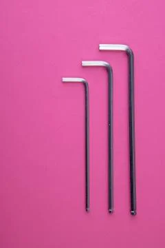 Three allen wrenches sorted by size on pink Stock Photos
