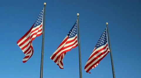 Three American flags against blue sky Stock Footage 18180579
