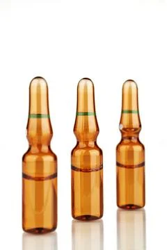 Three ampoules with reflection on a white background. Stock Photos