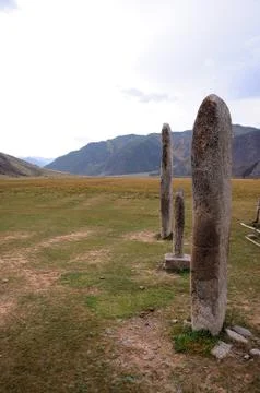 Three ancient stone statues stand in a row in the center of the intermountain Stock Photos