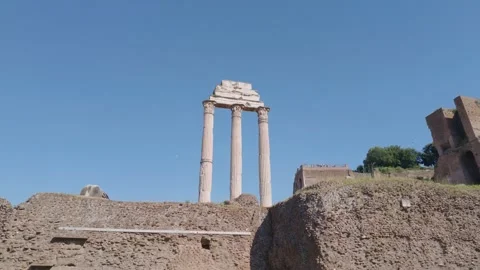 Three Ancient Temple Columns at Roman Forum Under Blue Sky Stockbeeldmateriaal 338008601