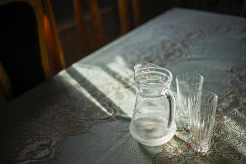 Three and empties. Selective focus on glass jug and glasses on the table. S.. Stock Photos