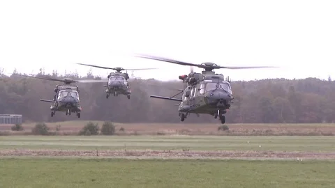 Three Apache Helicopters Take Off and Plan Above Ground, US Armed Forces Stock Footage 120948482