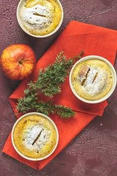 Three apple pies in ceramic baking molds ramekin with napkin, apple, spruce b Stock Photos