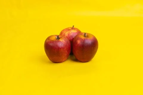 Three apple on yellow background Stock Photos