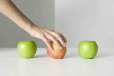 Three apples, hand selecting red apple Foto stock