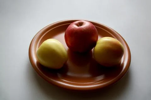 Three apples on plate Stock Photos