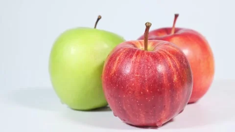 Three apples, red and green with drops of water, rotate on white background. Clo Video stock 247177564
