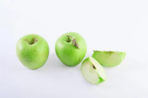 Three apples on a white background. A sliced apple on a white background. Com Stock Photos