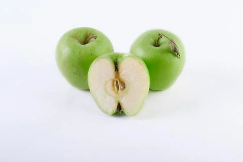 Three apples on a white background. A sliced apple on a white background. Com Stock Photos