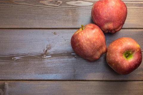 Three apples on the wooden table Stock Photos