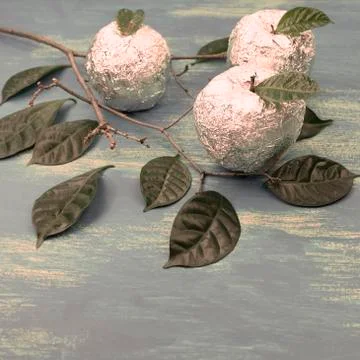 Three apples wrapped in foil are natural green leaves. Stock Photos