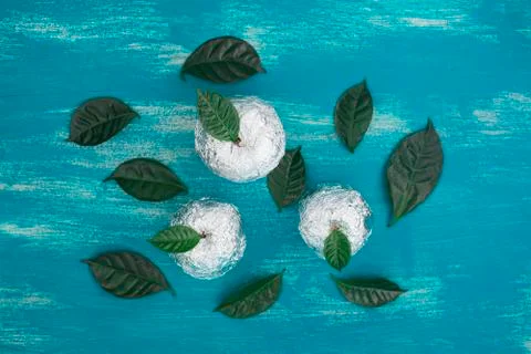 Three apples wrapped in foil are natural green leaves. Stock Photos