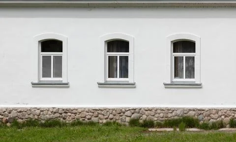 Three arched sash windows set in a white plaster facade Stock Photos