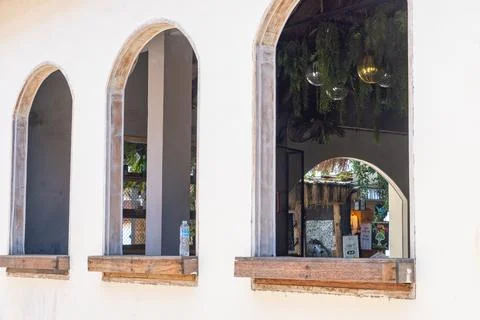 Three arched windows with a view of a restaurant Stock Photos