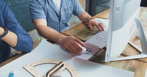 Three architectures working on a building plan. Young specialists collaborating Stock Footage 107749600