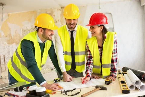 Three arhitects working together on construction site project Stock Photos