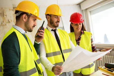Three arhitects working together on construction site project Stock Photos