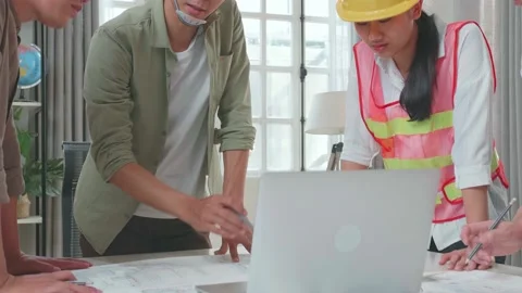 Three Asian Engineers With Helmets Using Laptop For Working To A Man Stock Footage 172423138