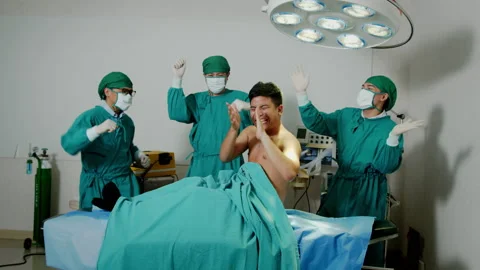 Three Asian male goofy surgeons and a patient dancing in Halloween themed party. Stock Footage
