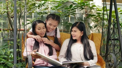 Three Asian Women Looking Through Book Stock Footage